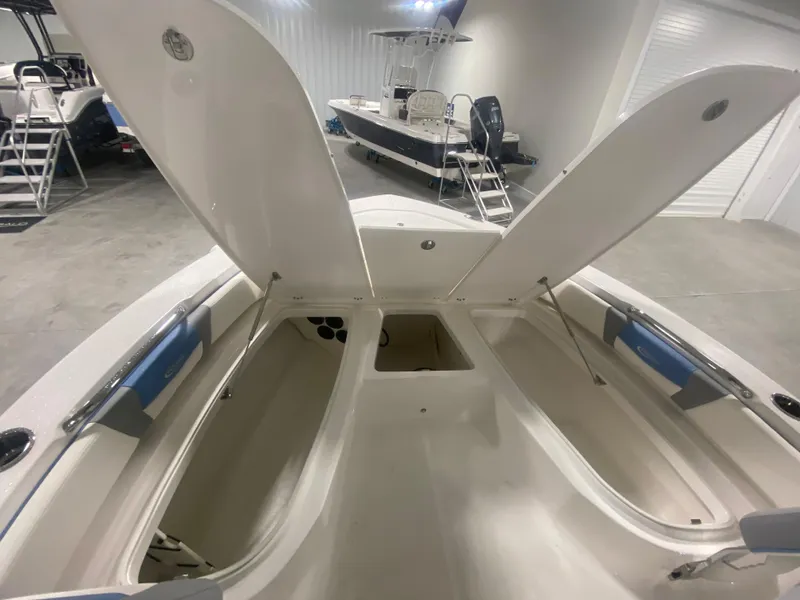 Slide: The Image of 2024 Robalo 206 Cayman boat with open storage compartments in a showroom. - 18