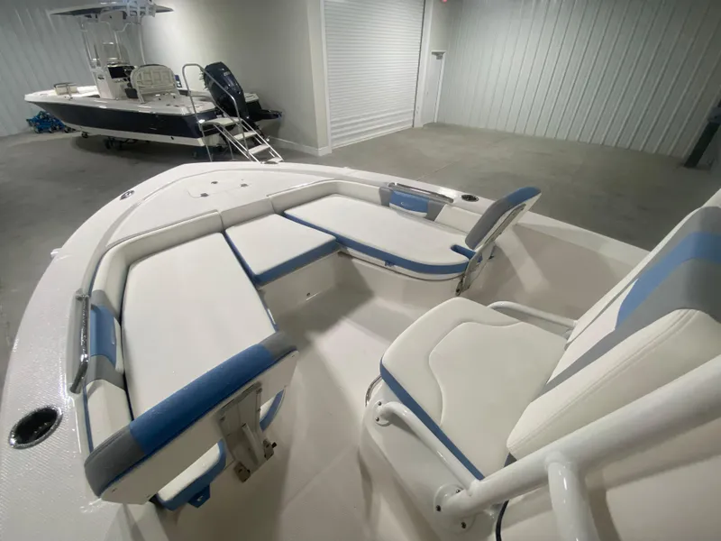 Slide: The Image of 2024 Robalo 206 Cayman boat interior with cushioned seating in a showroom. - 12