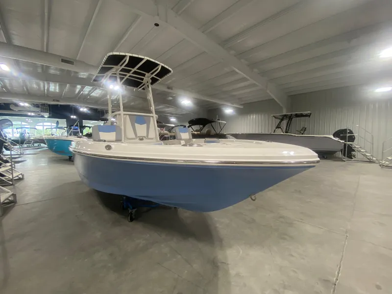 Slide: The Image of 2024 Robalo 206 Cayman boat displayed in a showroom. - 2