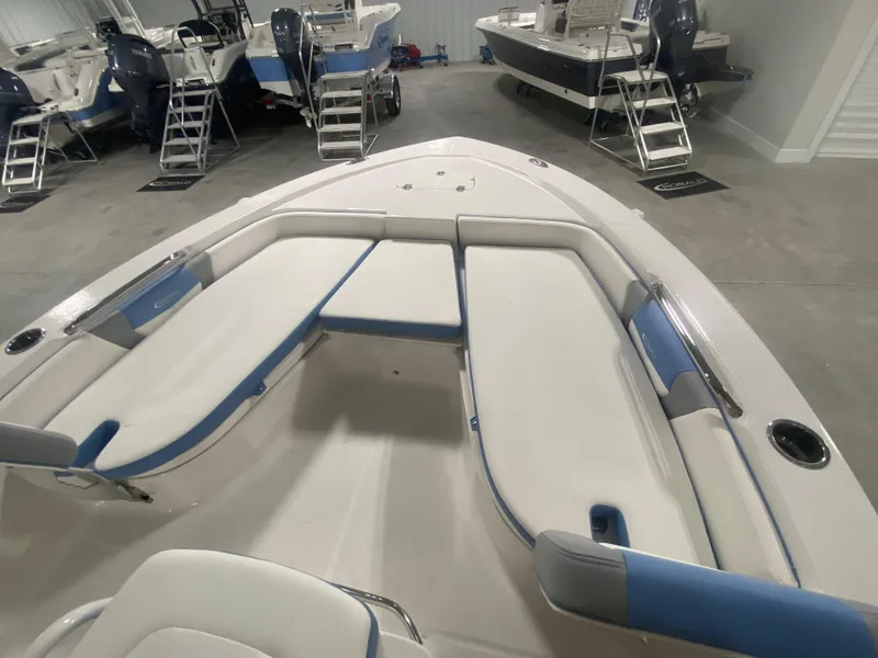Slide: The Image of 2024 Robalo 206 Cayman boat interior with cushioned seating in a showroom. - 21