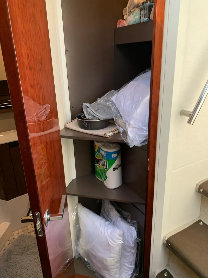 Slide: The Image of Storage cabinet in 2017 Sea Ray Sundancer 460 yacht with pillows and paper towels. - 42
