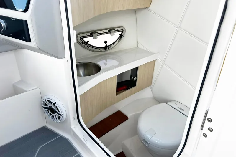 Slide: The Image of 2024 Regal LS9 boat interior with compact bathroom, featuring a toilet and sink. - 12