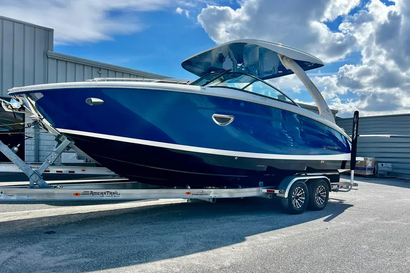 Slide: The Image of 2024 Regal LS9 boat on trailer, blue hull, modern design, parked outdoors under cloudy sky. - 4