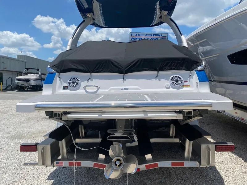 Slide: The Image of 2024 Regal LS9 boat on trailer, rear view with covered deck and propeller. - 5