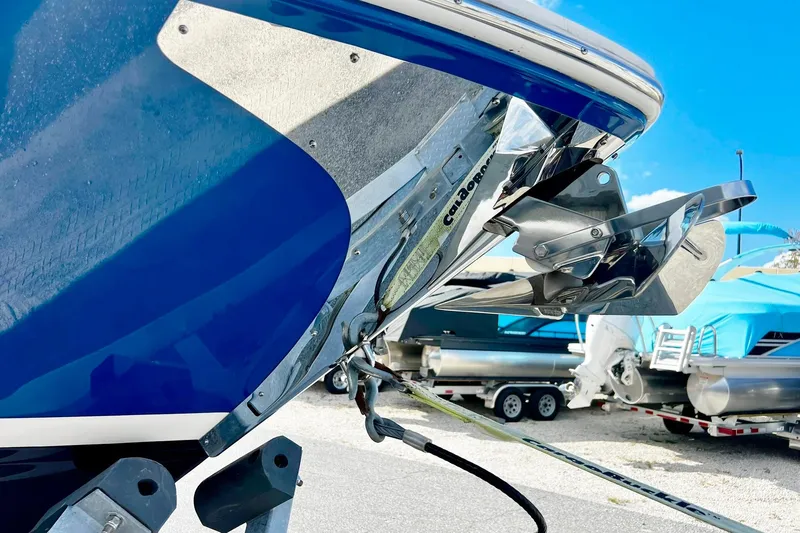Slide: The Image of 2024 Regal LS9 boat with stainless steel anchor, blue hull, and clear sky background. - 7