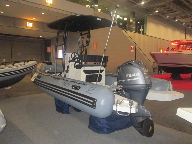 Slide: The Image of 2024 Zodiac Pro 5.5 inflatable boat with Yamaha outboard motor at indoor boat show. - 2