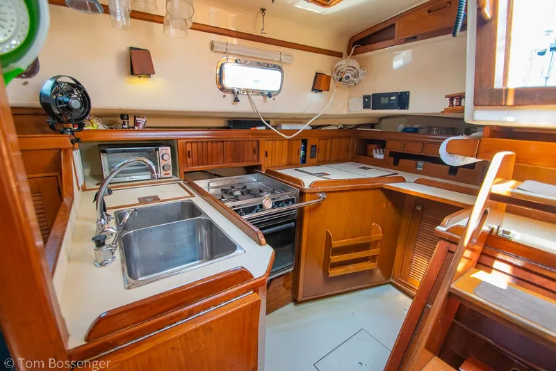 Slide: The Image of Interior of 1997 Island Packet 45 sailboat kitchen with wooden cabinetry and appliances. - 11