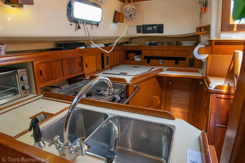 Slide: The Image of Interior of 1997 Island Packet 45 sailboat kitchen with wooden cabinetry and stainless steel sink. - 13