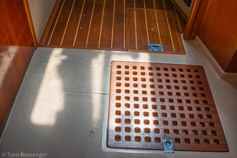 Slide: The Image of Interior flooring of 1997 Island Packet 45 sailboat, featuring wooden and textured surfaces. - 17