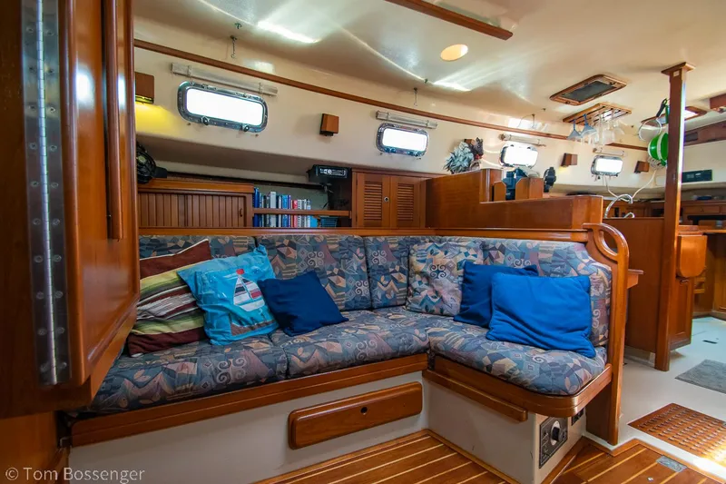 Slide: The Image of Cozy interior of 1997 Island Packet 45 sailboat with cushioned seating and wooden accents. - 19