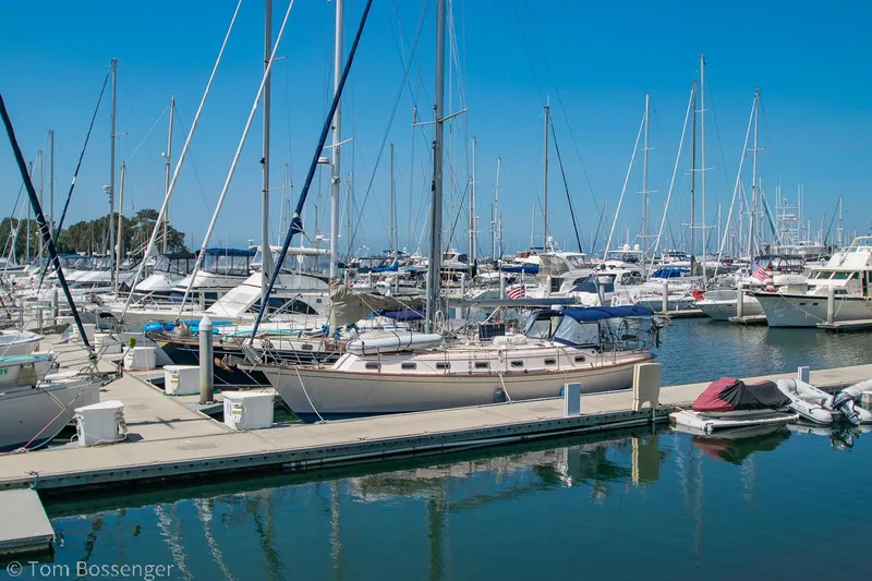 Slide: The Image of Sailboats docked at a marina, featuring a 1997 Island Packet 45 under clear blue skies. - 2
