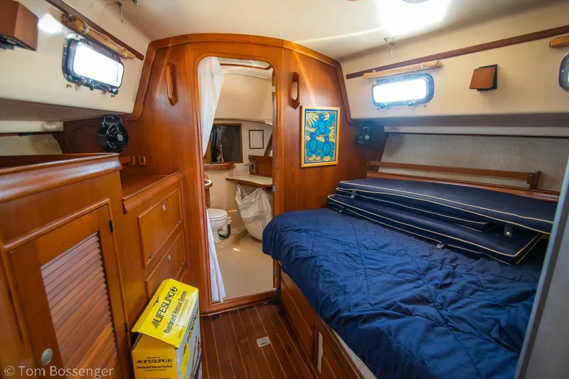 Slide: The Image of Cozy cabin interior of 1997 Island Packet 45 sailboat with wooden furnishings and blue bedding. - 23