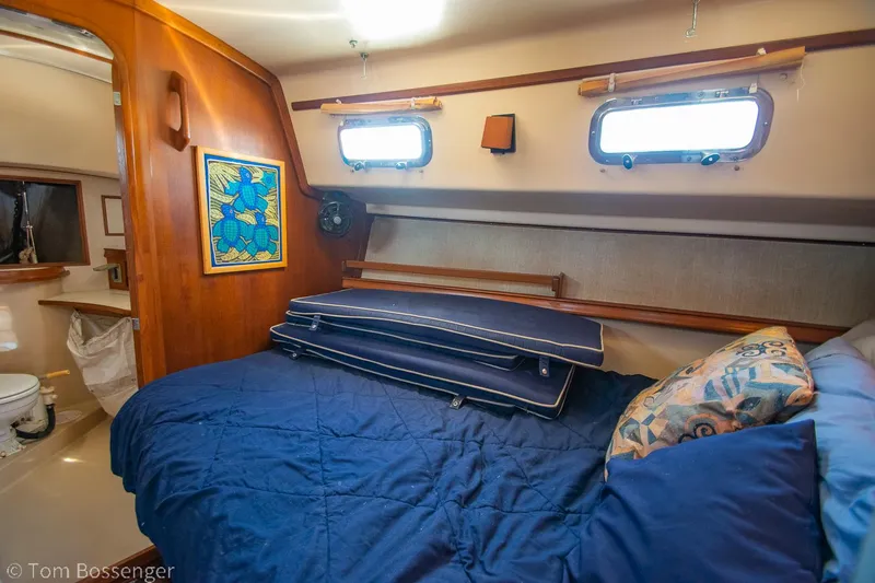 Slide: The Image of Cozy cabin interior of 1997 Island Packet 45 sailboat with blue bedding and wooden accents. - 24