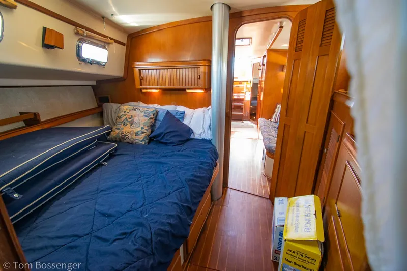 Slide: The Image of Cozy cabin interior of 1997 Island Packet 45 sailboat with bed and wooden furnishings. - 25
