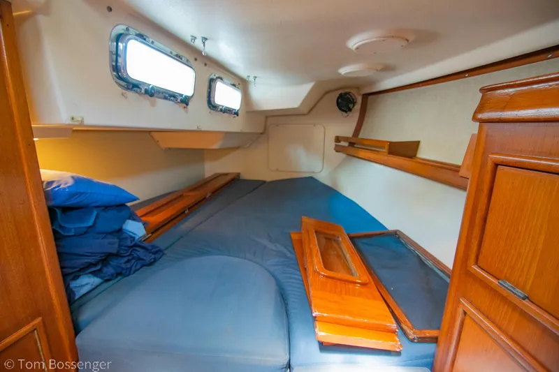 Slide: The Image of Cozy cabin interior of 1997 Island Packet 45 sailboat with wooden accents and blue bedding. - 29