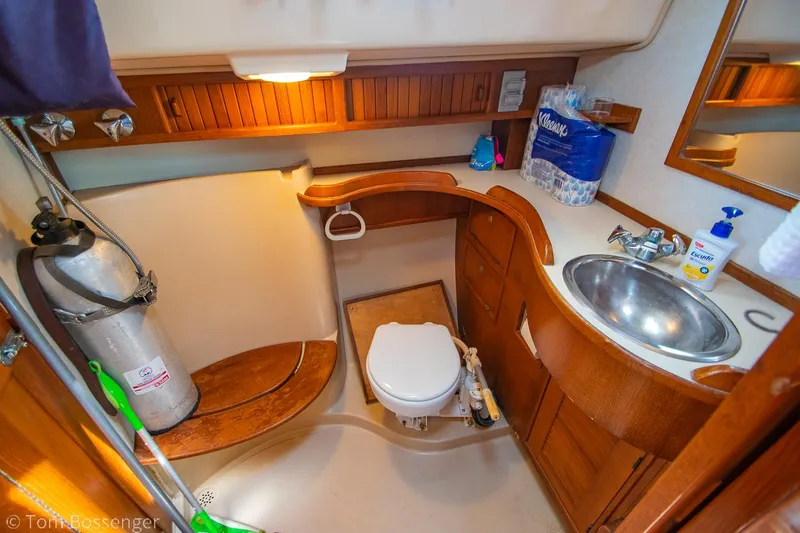 Slide: The Image of 1997 Island Packet 45 yacht bathroom with wooden cabinetry, sink, and toilet. - 30