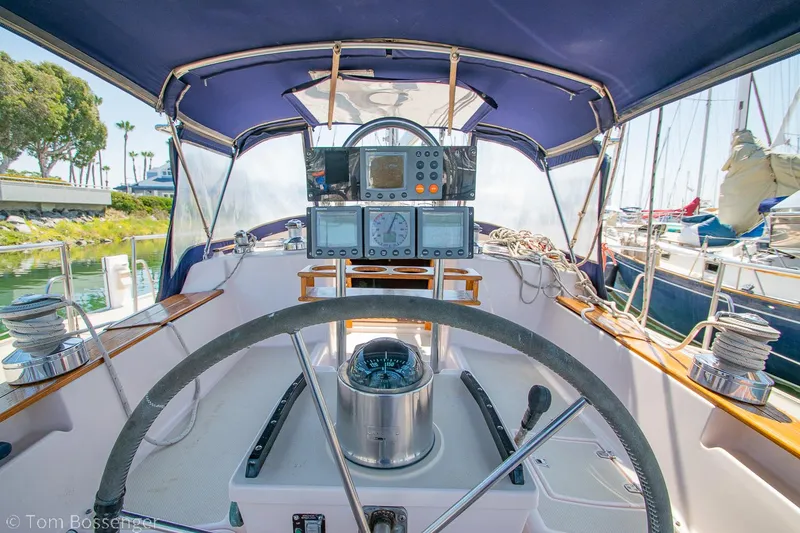 Slide: The Image of Cockpit of a 1997 Island Packet 45 sailboat with navigation equipment and steering wheel. - 36