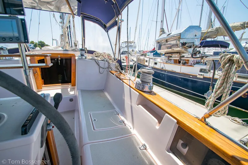 Slide: The Image of 1997 Island Packet 45 sailboat cockpit with wooden trim, docked in a marina. - 38