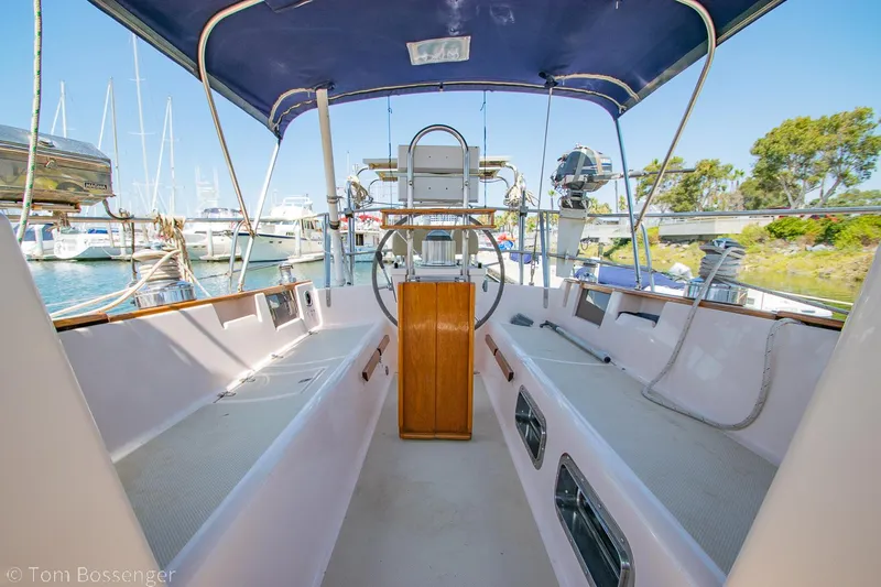 Slide: The Image of 1997 Island Packet 45 sailboat cockpit with blue canopy, docked at marina. - 41