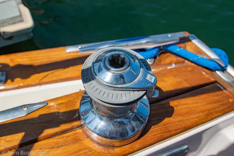 Slide: The Image of Chrome winch on 1997 Island Packet 45 sailboat deck, with polished wood and blue rope. - 43