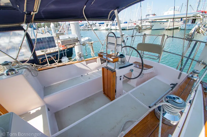 Slide: The Image of 1997 Island Packet 45 sailboat cockpit with steering wheel, docked in marina. - 5