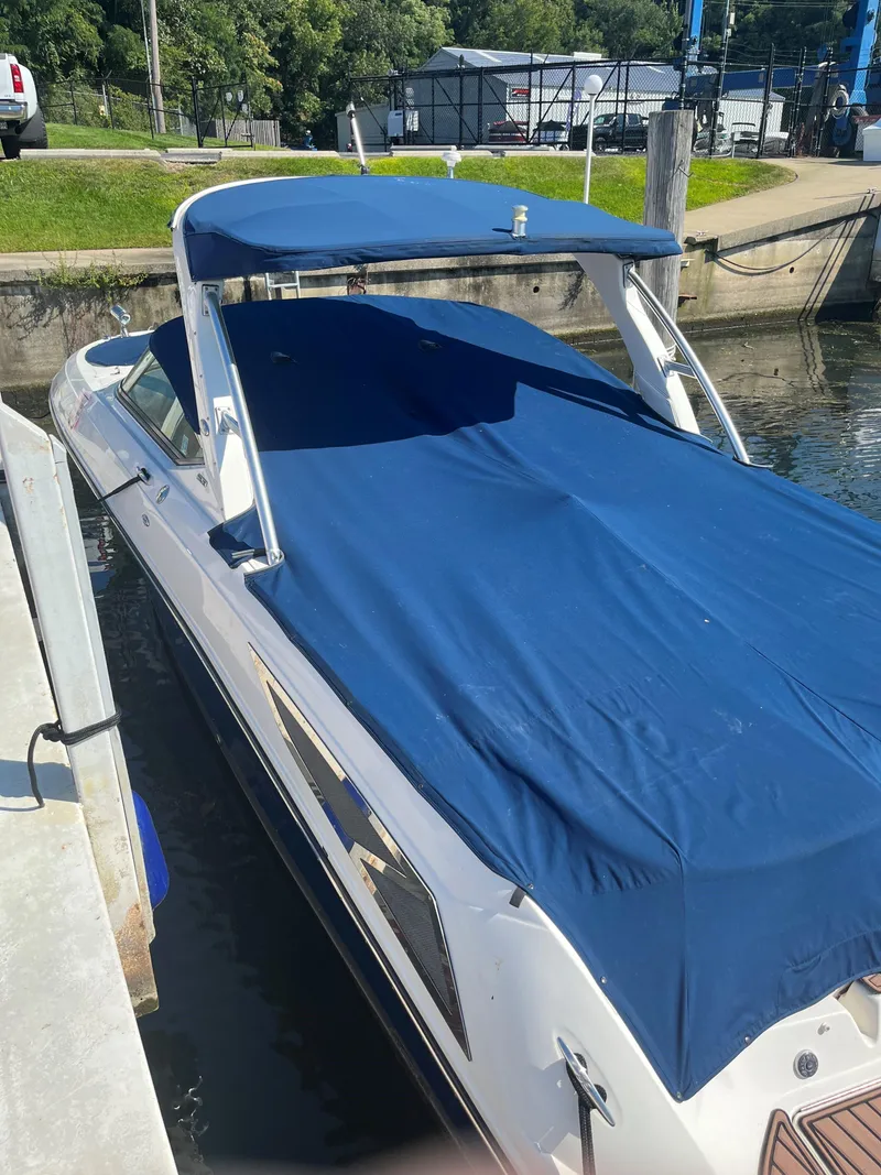 Slide: The Image of 2013 Sea Ray 300 SLX boat docked with blue cover and canopy. - 13