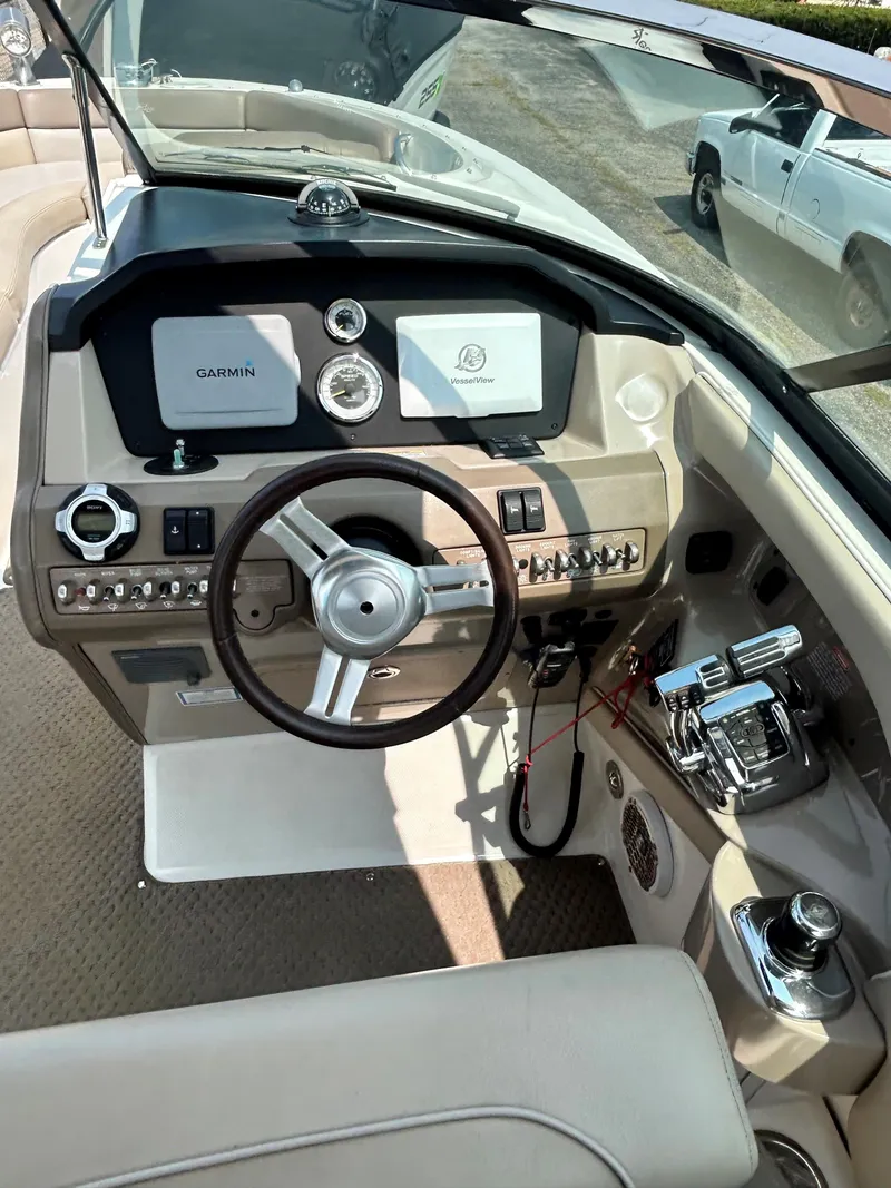 Slide: The Image of 2013 Sea Ray 300 SLX boat cockpit with Garmin navigation system and steering wheel. - 16