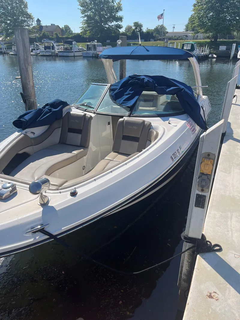 Slide: The Image of 2013 Sea Ray 300 SLX boat docked at a marina with blue canopy. - 2