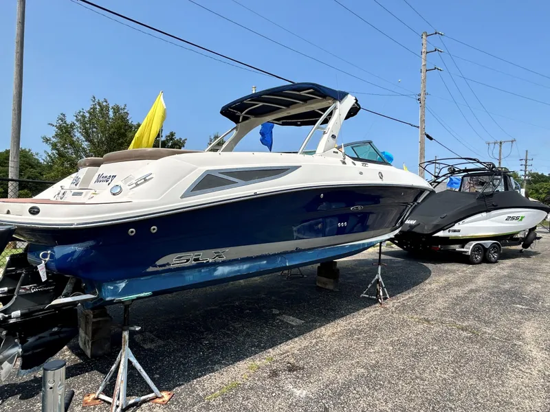 Slide: The Image of 2013 Sea Ray 300 SLX boat on stands in a parking lot. - 4