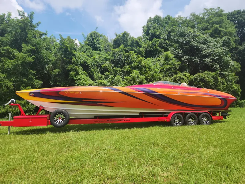 The Image of 2004 Eliminator 380 Eagle speedboat on a red trailer, parked on grass. - 0