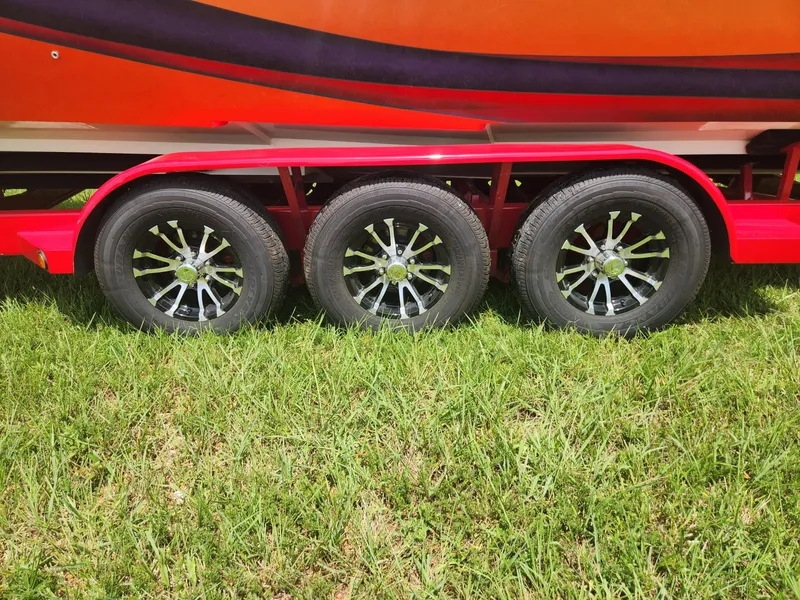Slide: The Image of 2004 Eliminator 380 Eagle boat trailer with triple axle wheels on grass. - 13