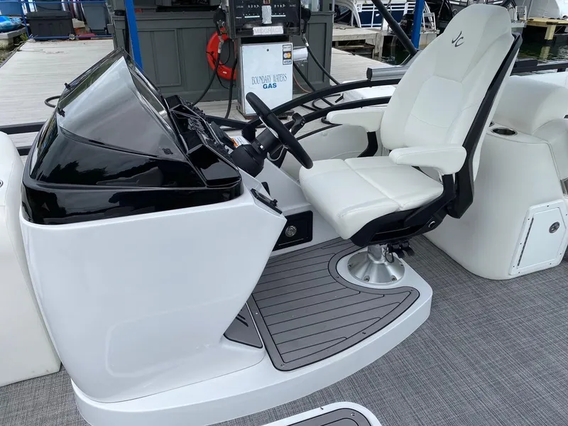 Slide: The Image of 2024 JC Neptoon Sport 23TT DSL boat helm with white captain's chair and steering wheel. - 14