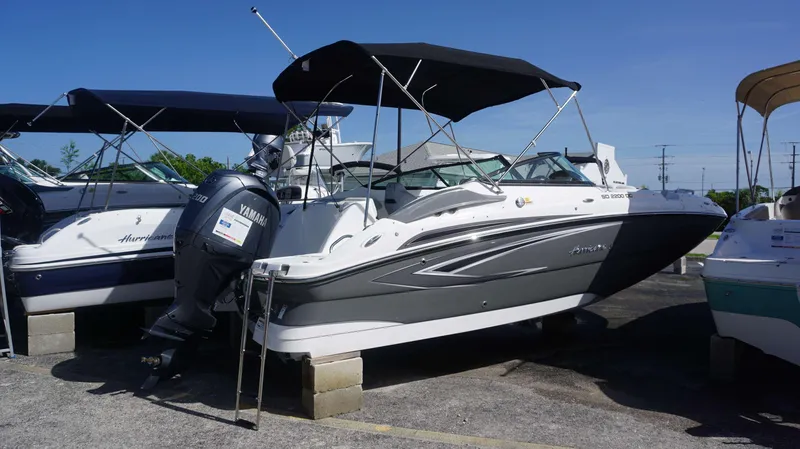 Slide: The Image of 2024 Hurricane 2200 SD boat with Yamaha engine, parked outdoors. - 2