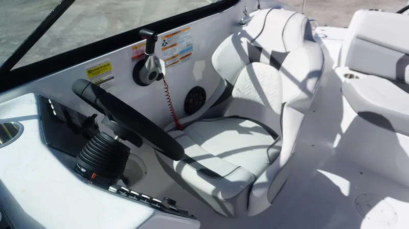 Slide: The Image of 2024 Hurricane 2200 SD boat cockpit with steering wheel and comfortable seating. - 9