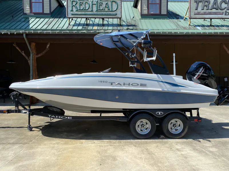 The Image of 2024 Tahoe 1950 boat on trailer outside a building. - 0