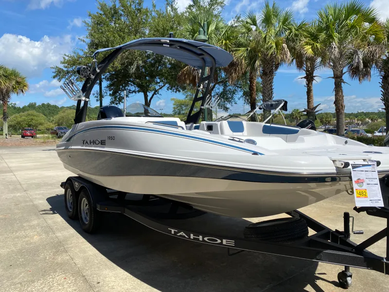 Slide: The Image of 2024 Tahoe 1950 boat on trailer, parked outdoors with palm trees in the background. - 1