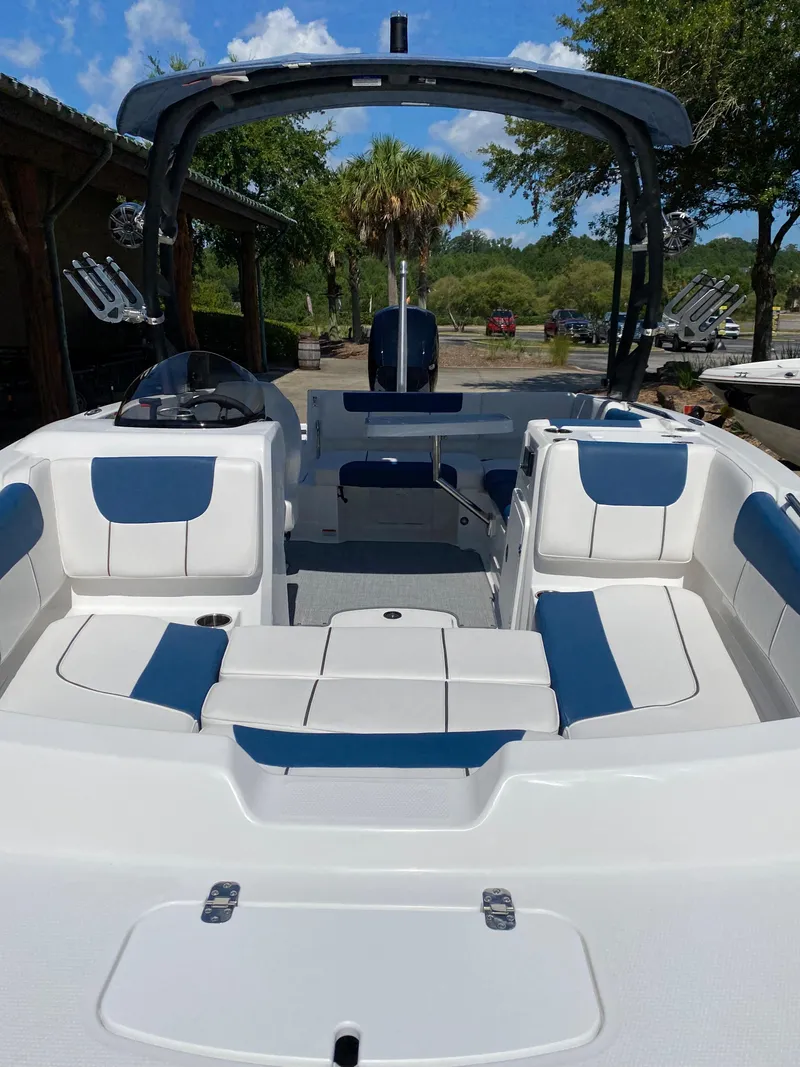 Slide: The Image of 2024 Tahoe 1950 boat with blue and white seating, docked outdoors. - 2