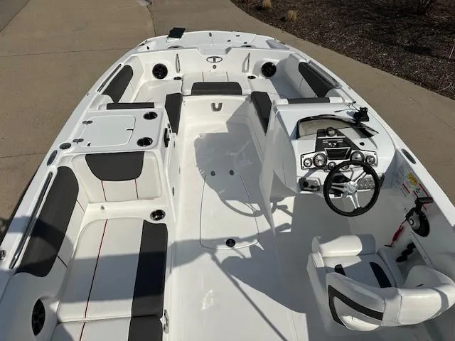Slide: The Image of 2024 Tahoe 2150 boat interior with seating, steering console, and cup holders. - 13