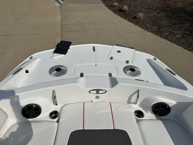 Slide: The Image of 2024 Tahoe 2150 boat deck with cup holders and speakers, parked on a concrete surface. - 3