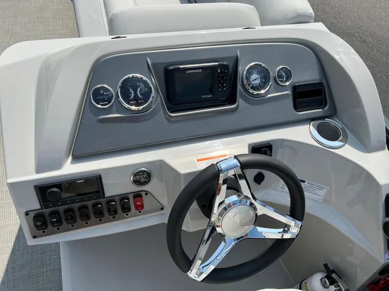 Slide: The Image of 2024 Crest Classic Fish 220 dashboard with steering wheel, gauges, and control panel. - 18