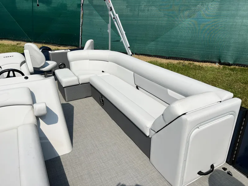 Slide: The Image of 2024 Crest Classic Fish 220 pontoon boat interior with white seating and helm. - 8