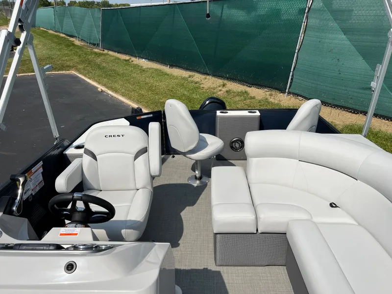 Slide: The Image of 2024 Crest Classic Fish 220 boat interior with white seating and steering wheel. - 9