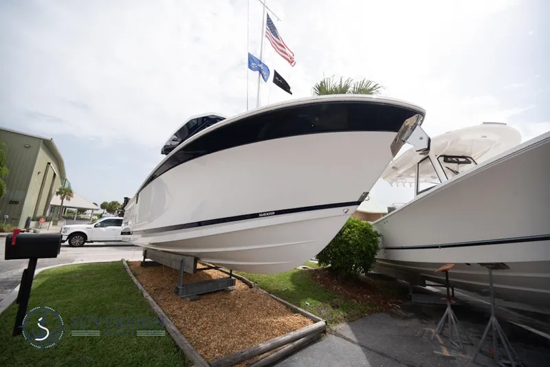 Slide: The Image of 2024 Blackfin 272 CC boat displayed outdoors, side view. - 2