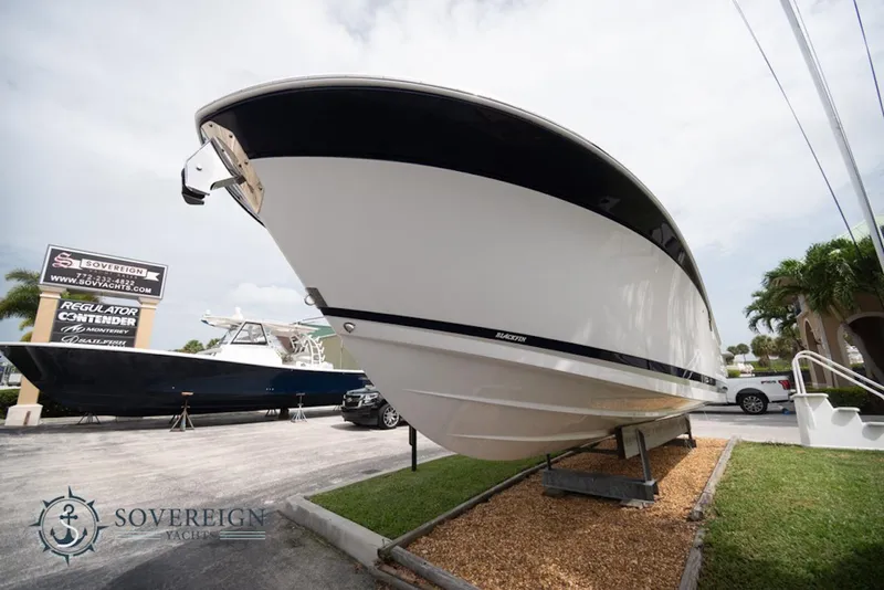 Slide: The Image of 2024 Blackfin 272 CC boat displayed outdoors at a dealership. - 3