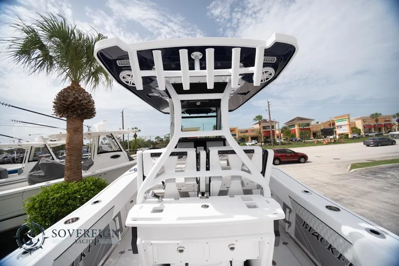 Slide: The Image of 2024 Blackfin 272 CC boat with T-top, parked outdoors near palm trees. - 8