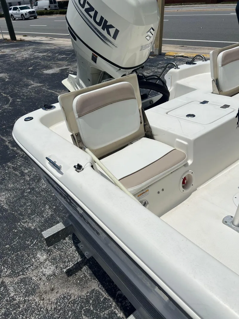 Slide: The Image of 2015 NauticStar 2110 Sport boat with Suzuki outboard motor, featuring comfortable seating. - 11