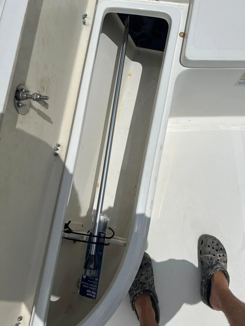 Slide: The Image of Open storage compartment on 2015 NauticStar 2110 Sport boat deck. - 16