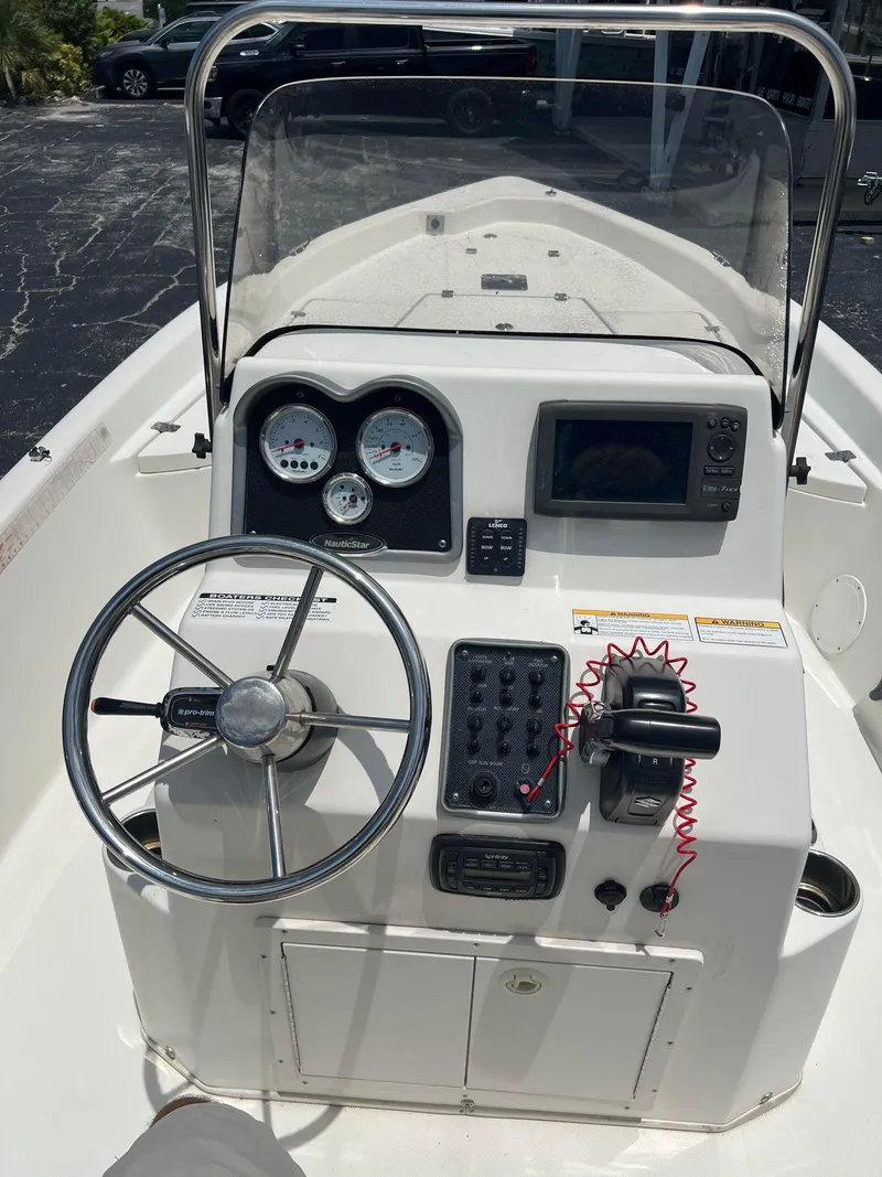 Slide: The Image of 2015 NauticStar 2110 Sport boat dashboard with steering wheel and control panel. - 17