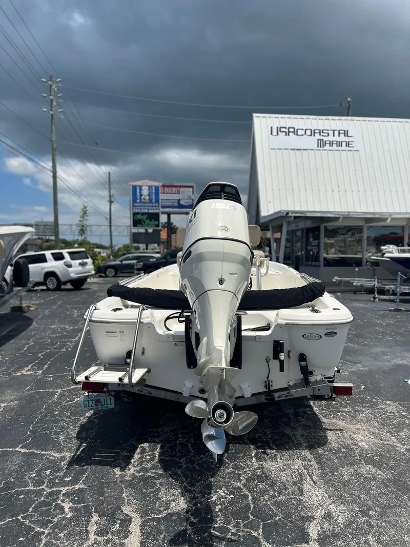 Slide: The Image of 2015 NauticStar 2110 Sport boat at dealership, rear view under cloudy sky. - 4