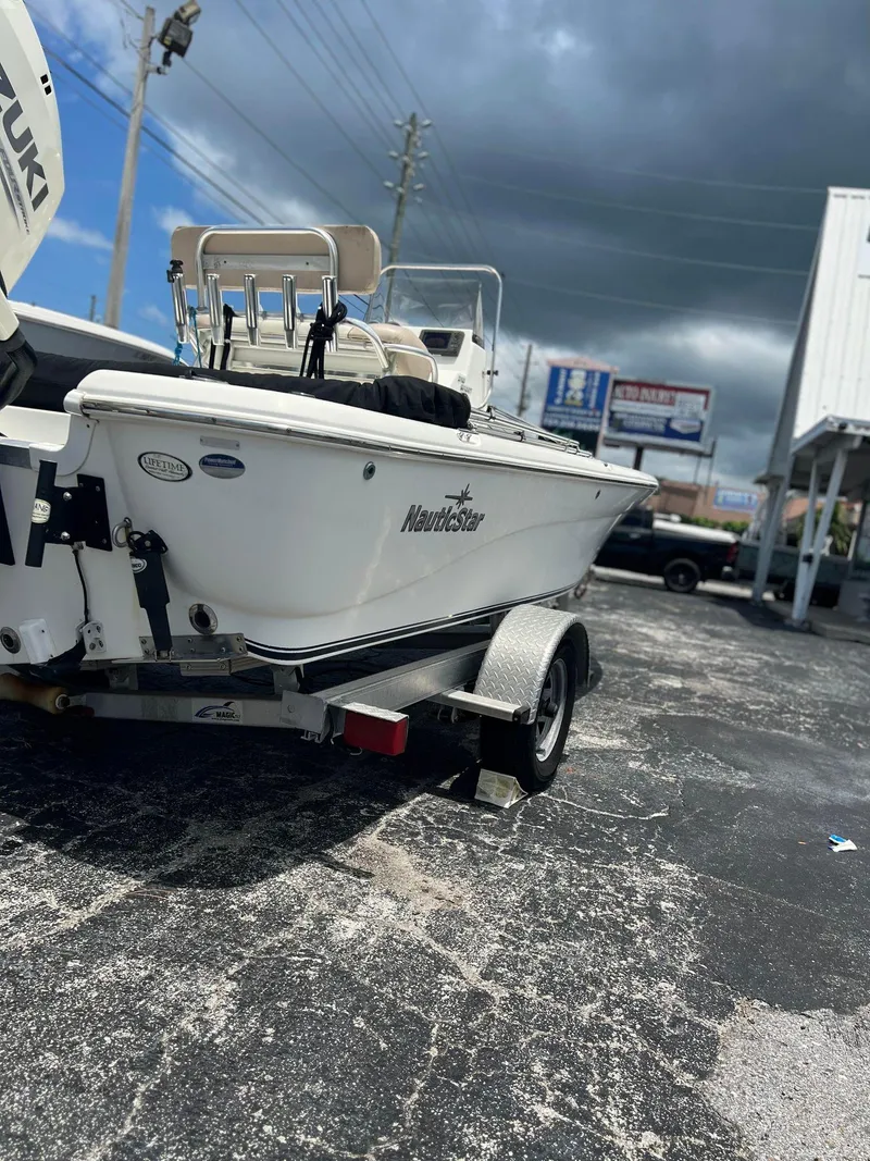 Slide: The Image of 2015 NauticStar 2110 Sport boat on trailer under cloudy sky. - 5